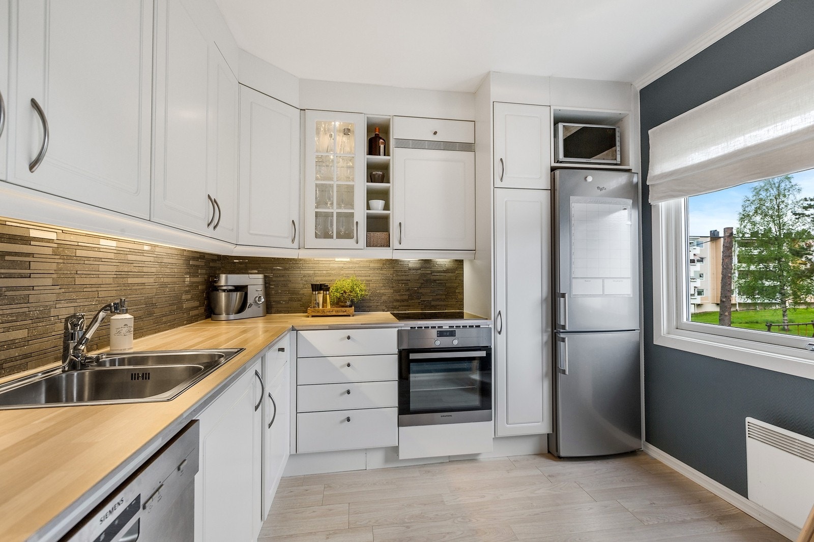 Kjøkkenet har en spiseplass foran vinduet Galleribilde