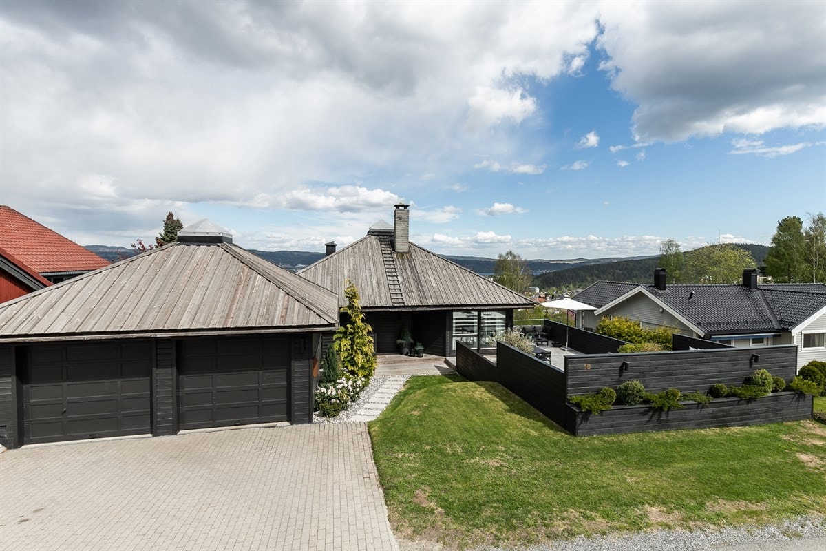 Det er parkering i dobbelgarasje og rom for flere biler på steinlagt gårdsplass. Galleribilde