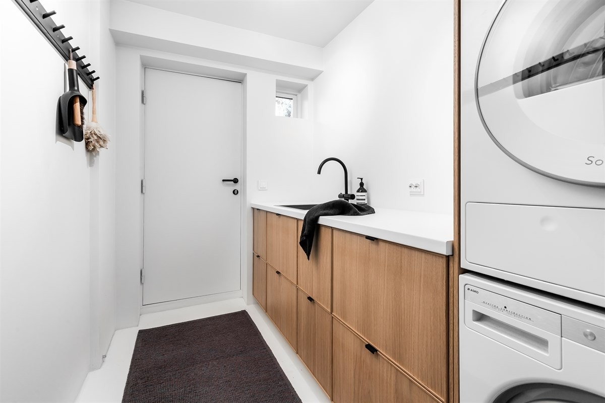 Vaskerommet ble pusset opp i 2017 og har malte, slette gulv og malte, glatte vegger. Innredningen fra Ikea har glatte fronter i eik og benkeplate i hel tre med nedfelt kum. Galleribilde