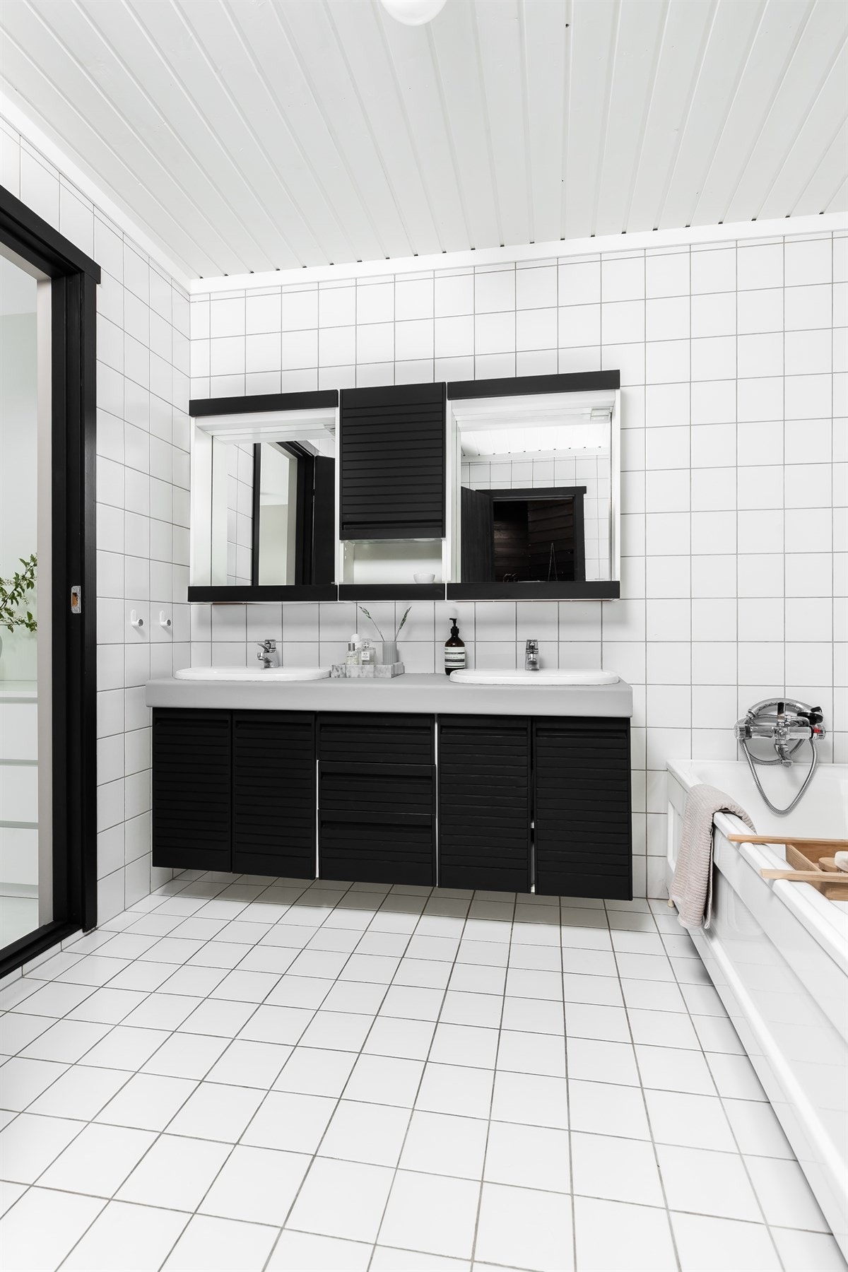 Dette badet har lyse fliser på gulv og vegger, gulvarme og trepanel i himling med lyskuppel. Galleribilde