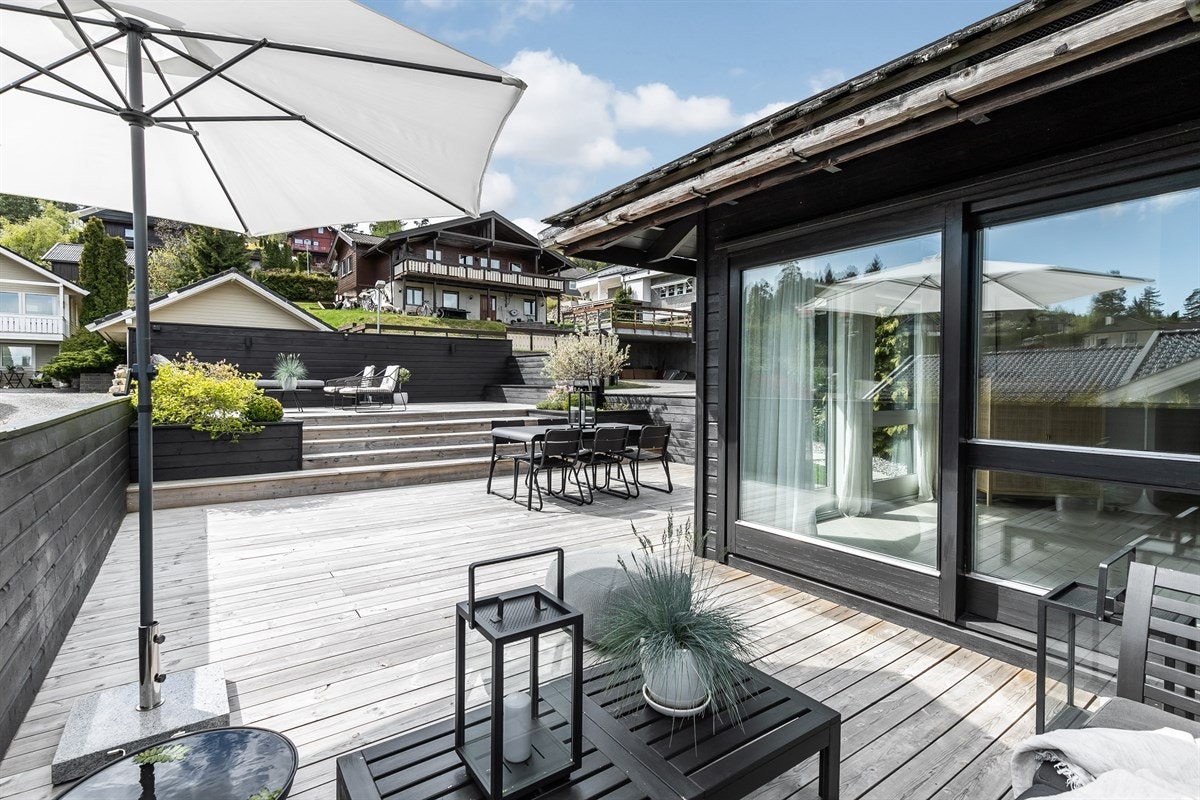 Terrassene har tredekke, mørkt rekkverk og glassrekkverk mot utsiktsiden. Galleribilde