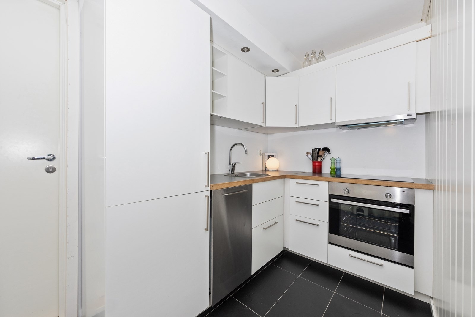 Hybel - Hybelkjøkkenet har en hvit Ikea-innredning med integrerte hvitevarer Galleribilde