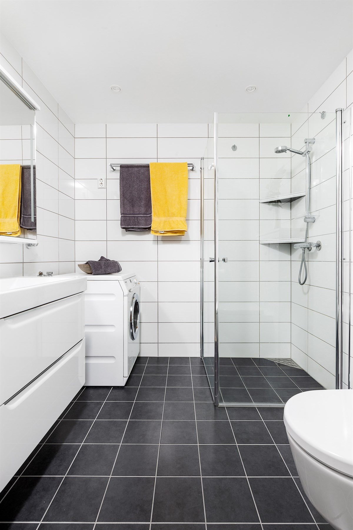 Komplett fliselagt bad med wc, dusjhjørne, opplegg for vaskemaskin, samt gulvvarme og downlights i taket