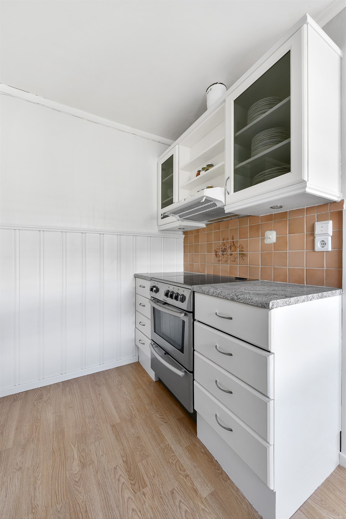 Over benk er det fliser og ventilator. Kjøkkenet har komfyrnisje, opplegg til oppvaskmaskin og plass til kjøleskap. Galleribilde