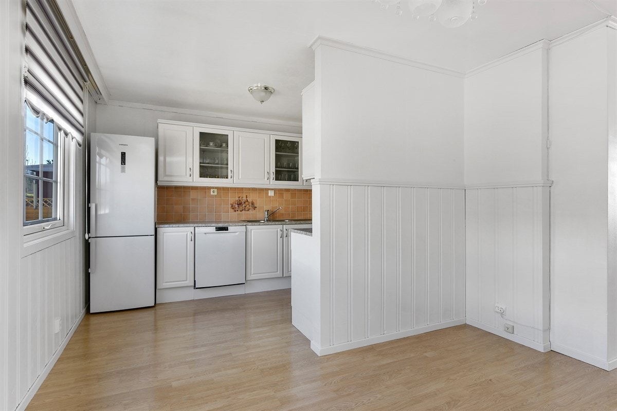 Kjøkkenet fra ca. 2004 ligger i delvis åpen løsning og har lysmalt innredning med profilerte furufronter. Galleribilde