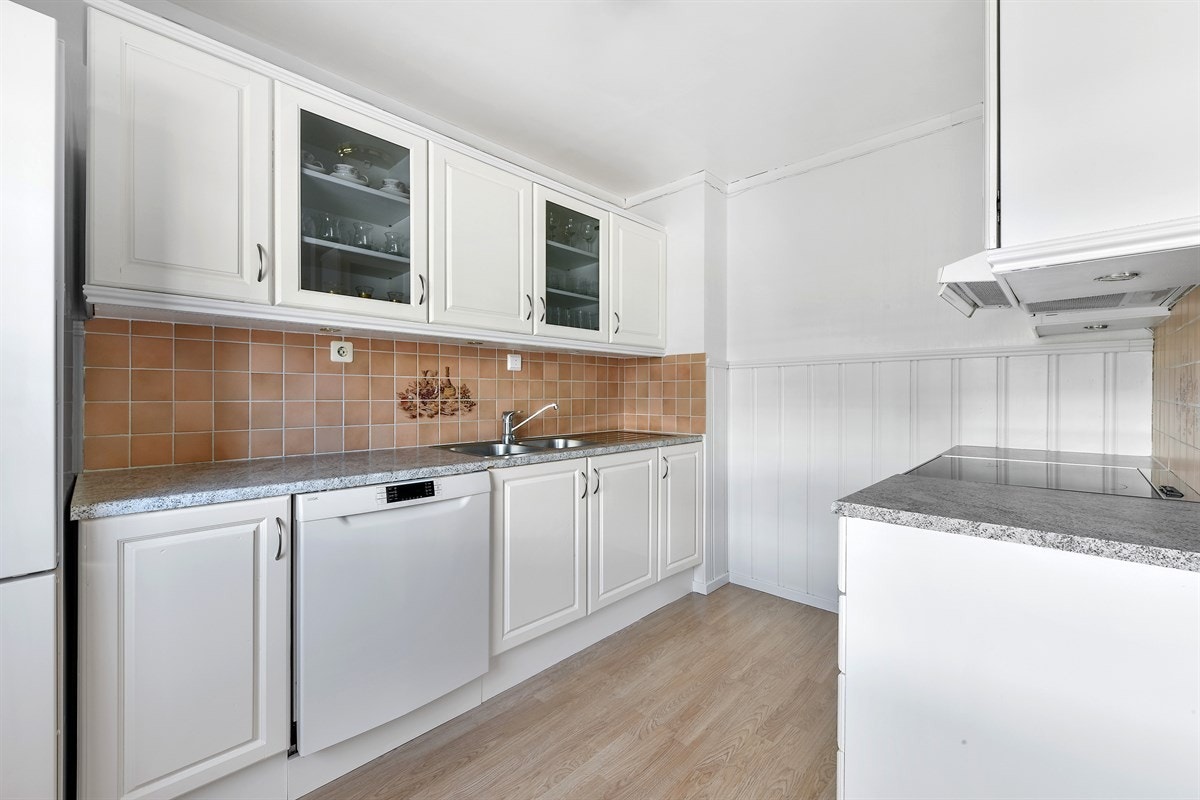 Det er innslag av vitrineskap og laminatbenkeplaten har dobbel oppvaskkum. Galleribilde