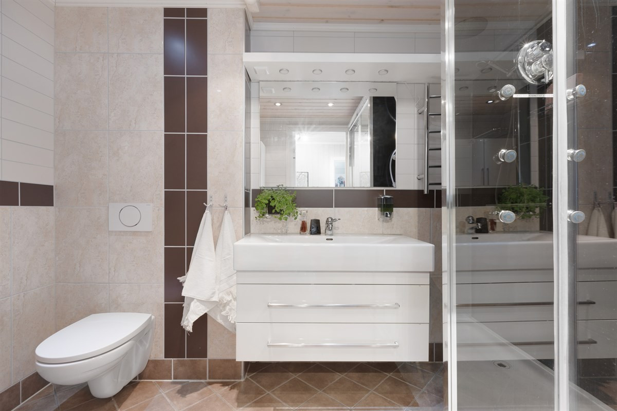Bad i 1. etasje fremstår moderne og er komplett fliselagt med varmekabler i gulv. Badet er renovert i 2009
