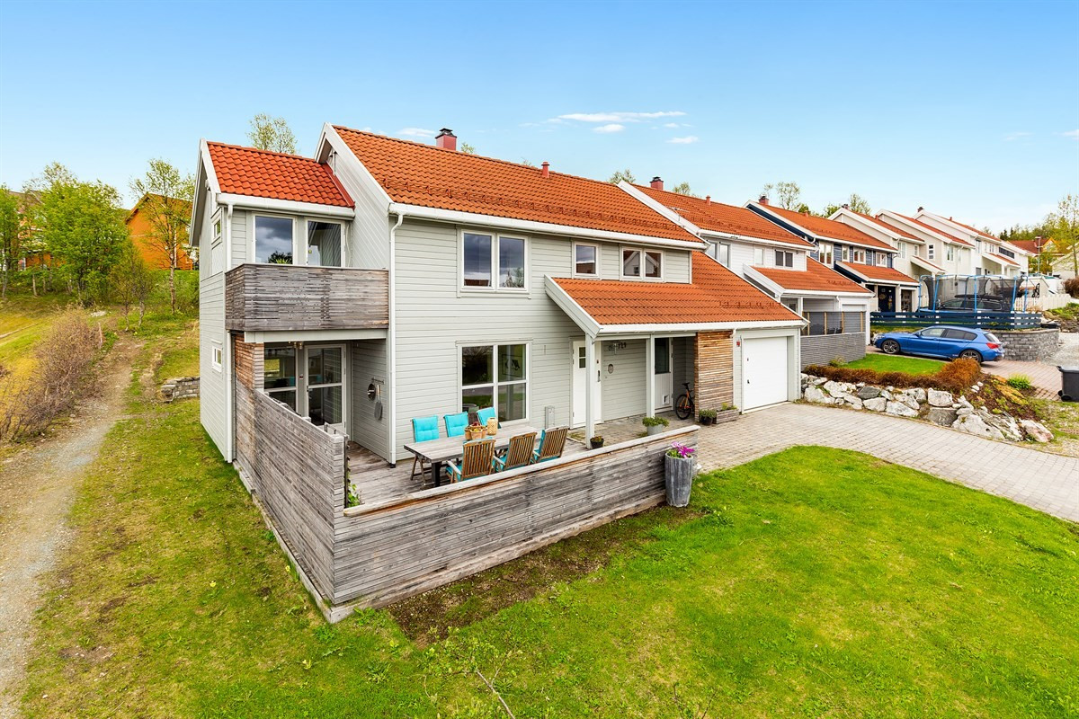 Vestvendt fasade med stor terrasse og veranda