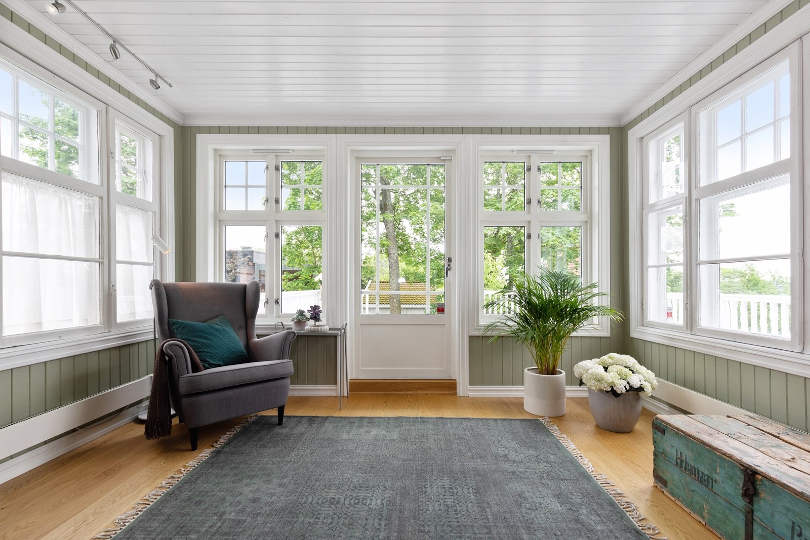 Glassveranda med lys fra alle kanter og utsikt til hage. Galleribilde