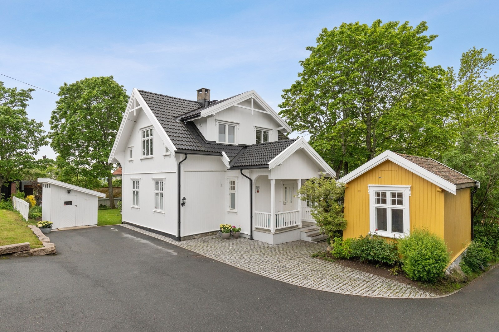 Uteområder med brostein, asfalt og støttemurer gir solid inntrykk av eiendommen. Galleribilde