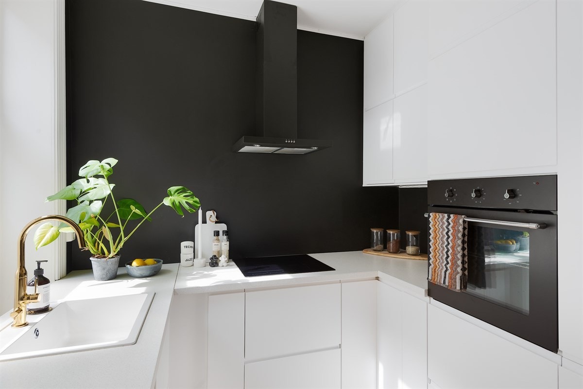 Stilrent kjøkken fra Ikea med hvite fronter og integrerte hvitevarer. Galleribilde
