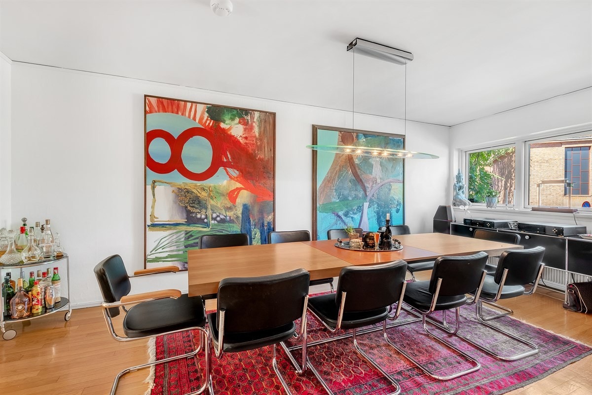 Romslig spisestue med stort vindusbelte på endeveggen Galleribilde