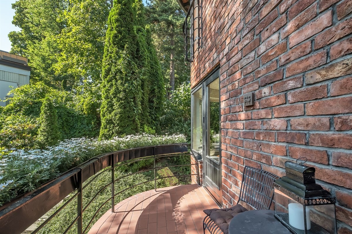 Balkongen er skjermet og solrik med hyggelig utsyn mot den flotte hagen Galleribilde