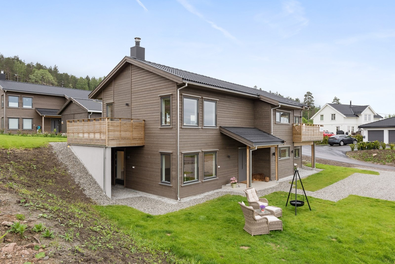 Tomten gir et flott inntrykk med velstelt plen, pent avsluttet til partier med lys grus og skråninger som kan beplantes Galleribilde