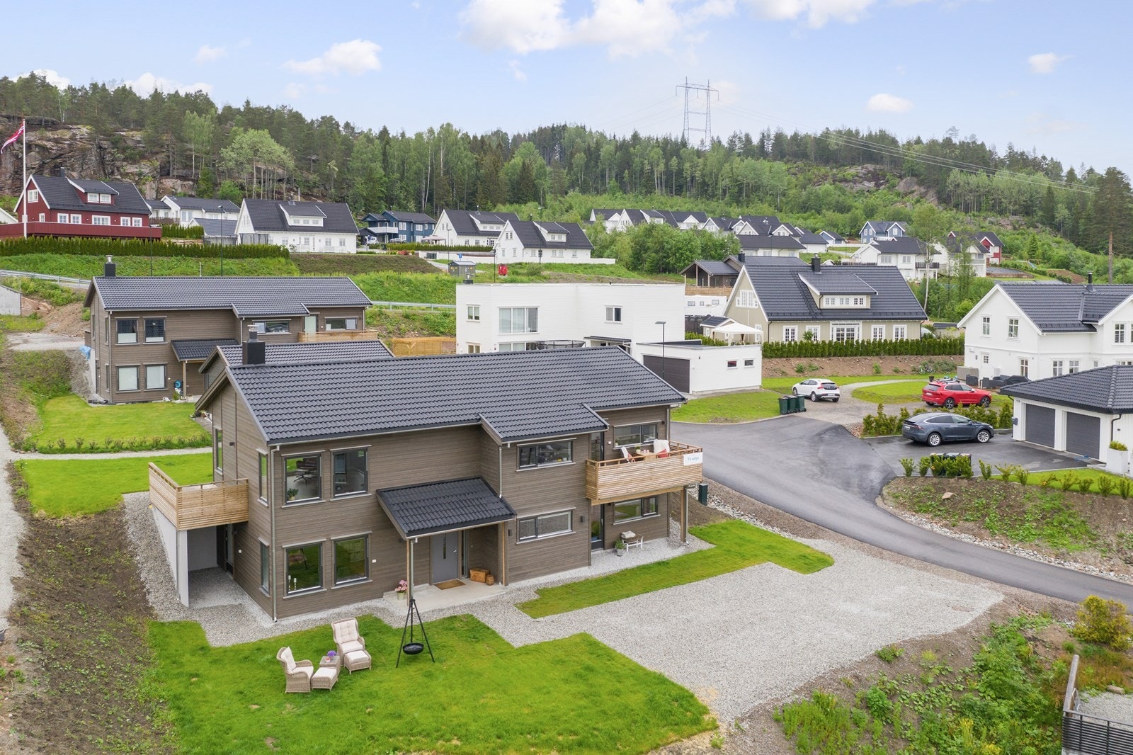 Huset faller naturlig inn blant bebyggelsen, velplassert i skrånende terrenget Galleribilde