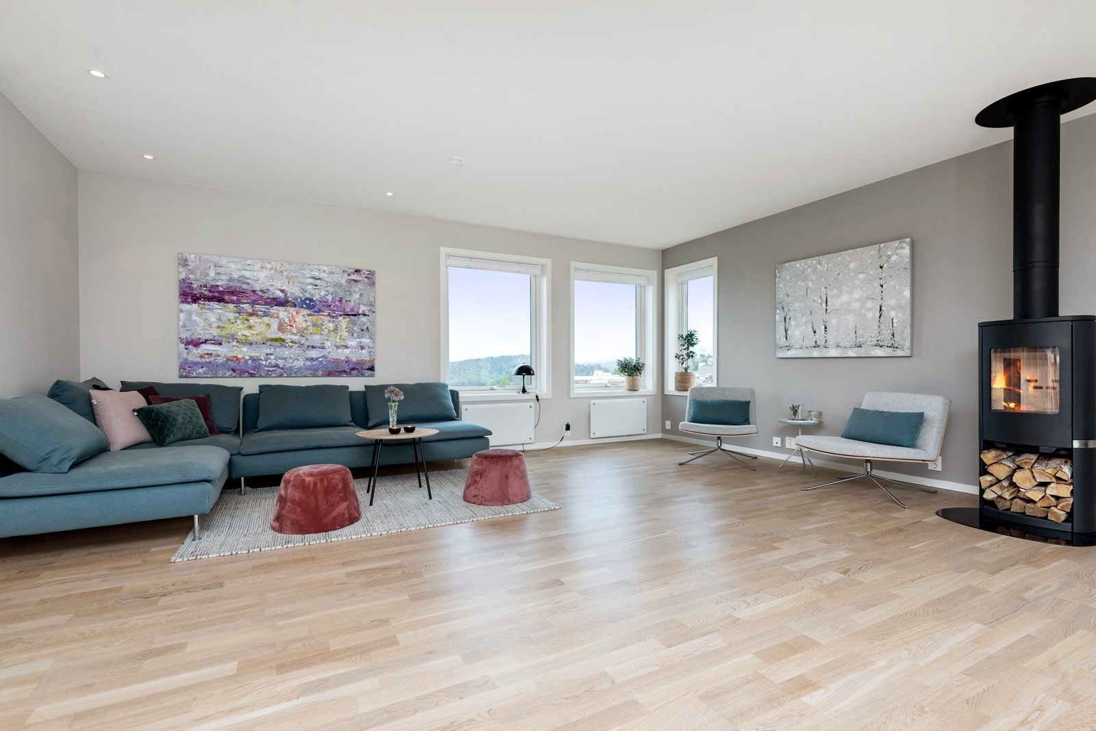 Stuen er luftig med gjennomgående lys fra store vinduer og skyvedør til hage Galleribilde