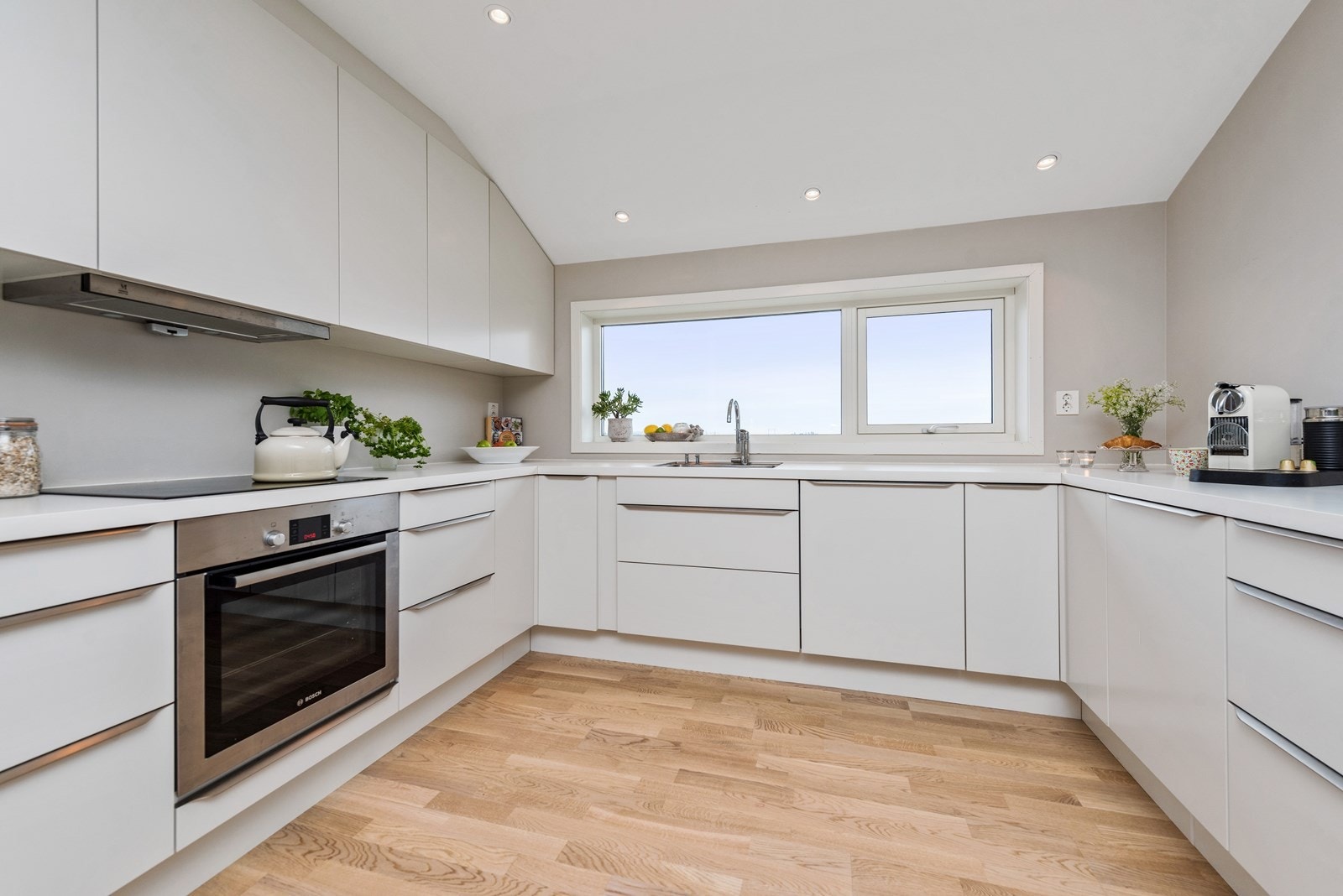 Kjøkkenet er fra HTH og i moderne stil med hvite, glatte fronter Galleribilde