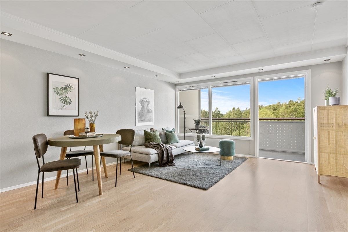 Lys og tiltalende stue med parkett i gulv og flater malt i en tidsriktig tone. Galleribilde