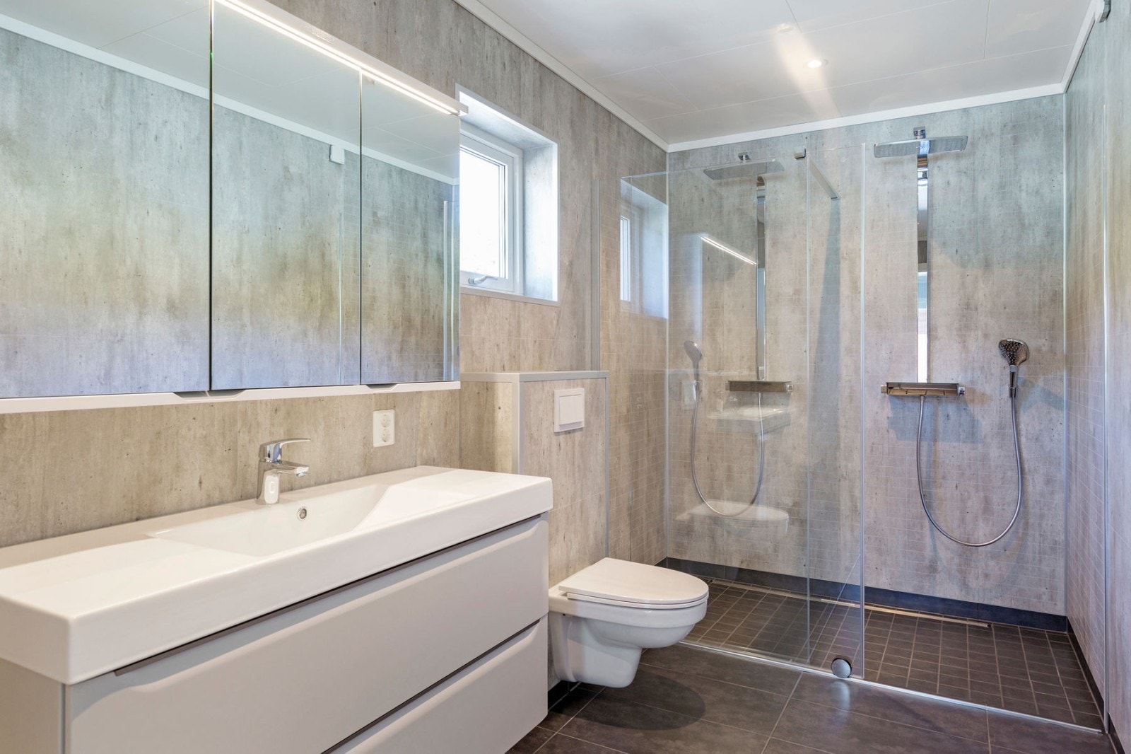 Det private badet har dobbel dusj og speilskap og heldekkende servantplate Galleribilde