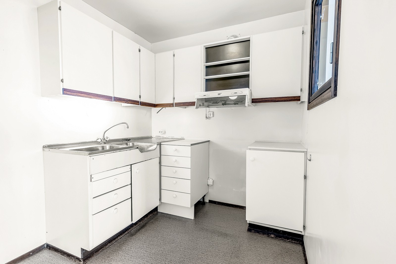 Kjøkkeninnredning med hvite fronter. Ventilator over platetoppen. Galleribilde