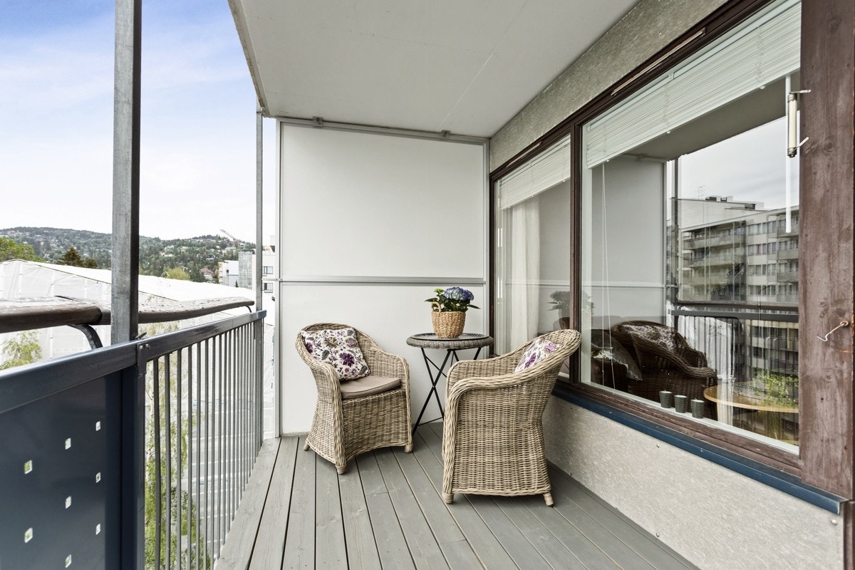 Romslig overbygget balkong med god plass til utemøbler Galleribilde