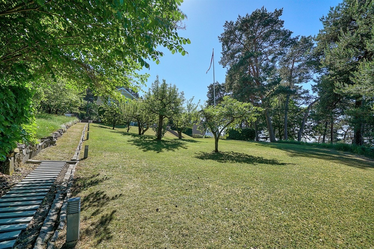 Veien opp fra bryggen - stor etablert og parkmessig hage med mange oppholdssoner Galleribilde