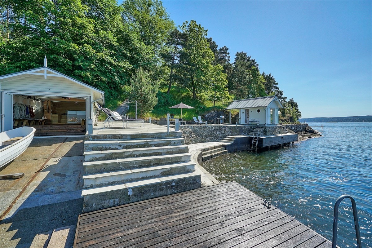 Helt unik og privat starndlinje på 75 m bryggefasiliteter med slipp, dypvannsbrygge, båthus og badehus Galleribilde