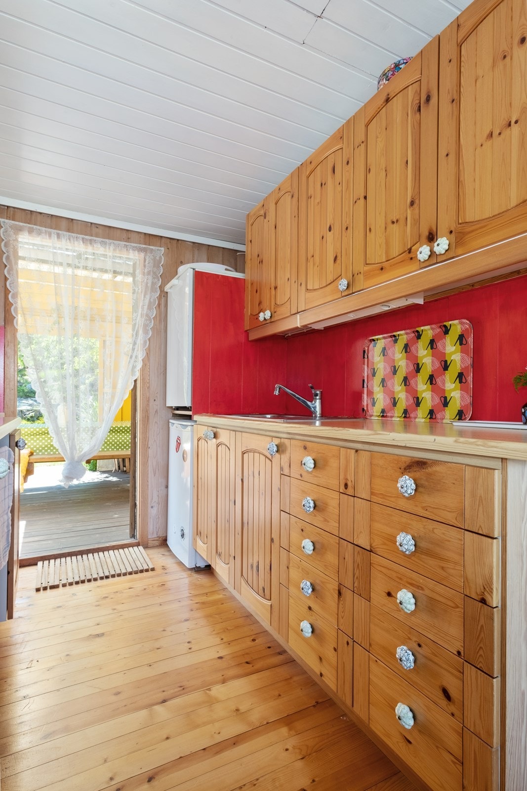 Kjøkken i tre med god skap- og benkeplass samt utgang til terrassen og hagen Galleribilde