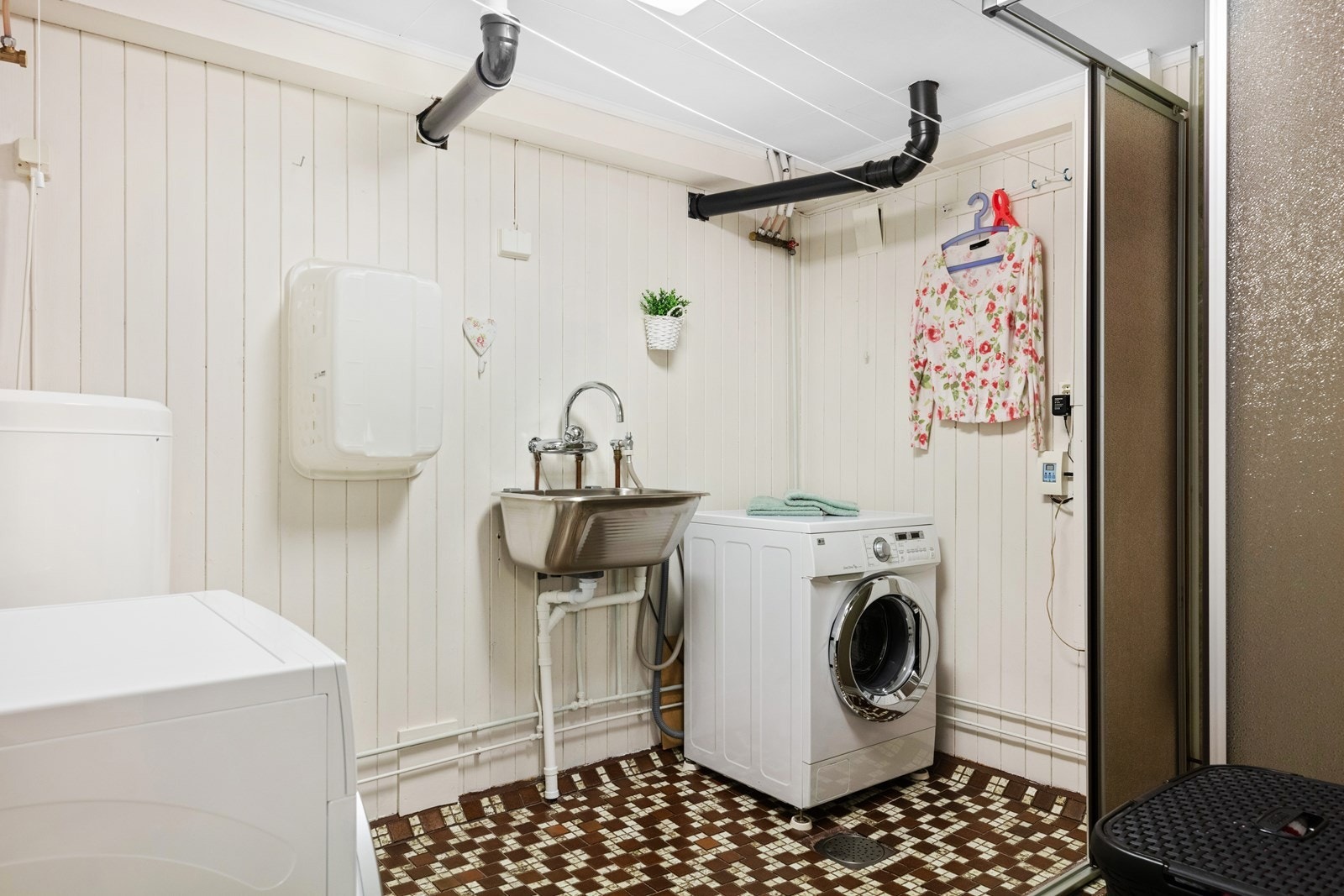 Vaskerom i kjeller med bl.a. mosaikkfliser på gulv, varmekabler i gulv, kum, dusjhjørne med skjermvegger og skyvedør, varmtvannsbereder på 194 liter fra 2002, samt vaskemaskin og tørketrommel som vil medfølge. Galleribilde