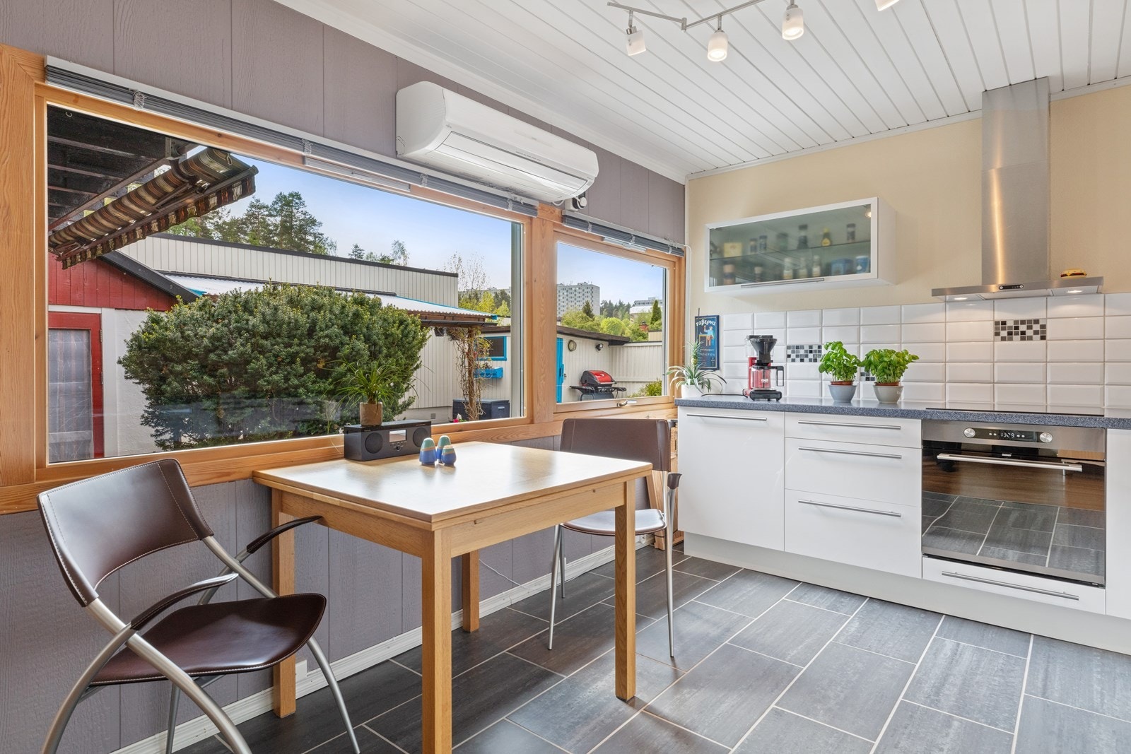 Trivelig spiseplass på kjøkken med store vinduer ut mot atrium. Galleribilde