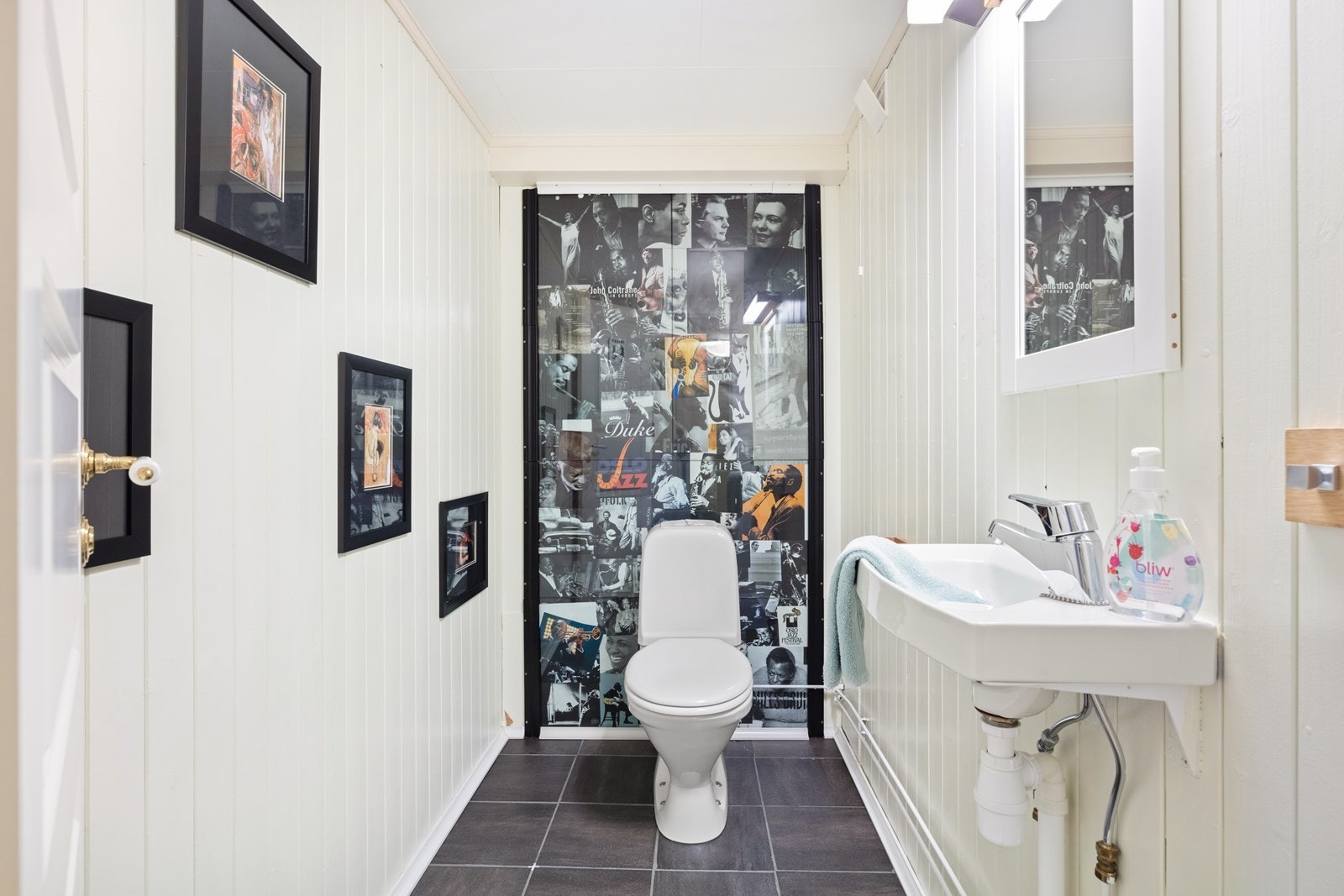 Wc i kjelleren har fliser på gulv og malt panel på vegger. Rommet er utstyrt med bl.a. klosett og servant. Galleribilde