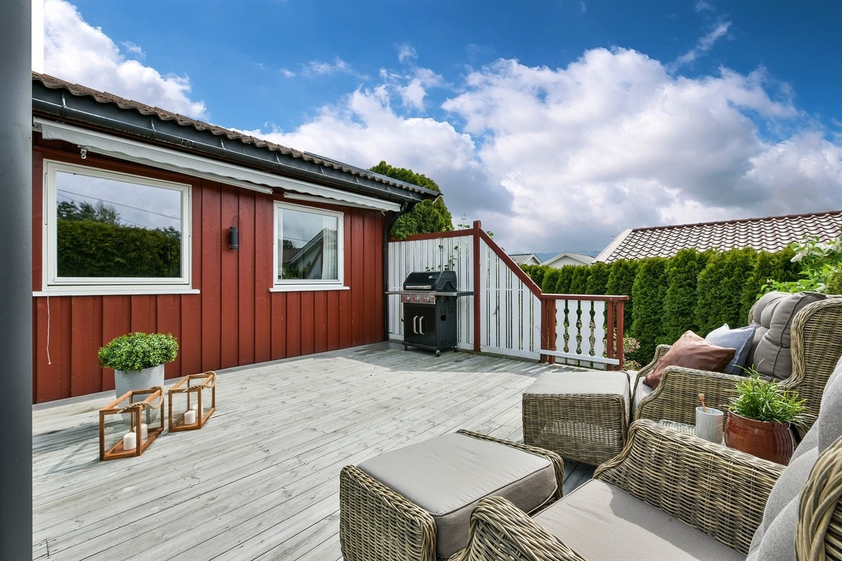 En terrassemarkise sørger for behagelig solskjerming, og det er trapp ned til hagen. Galleribilde