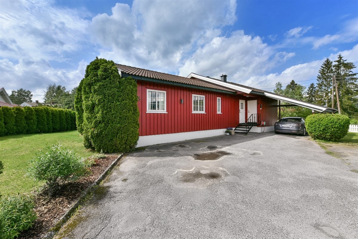 Det er parkering i carport og på asfaltert gårdsplass. Galleribilde