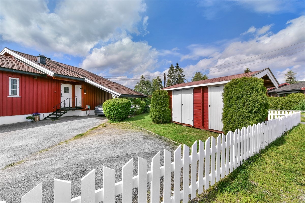 Den romslige gårdsplassen er asfaltert, og det er frittliggende utebod. Galleribilde