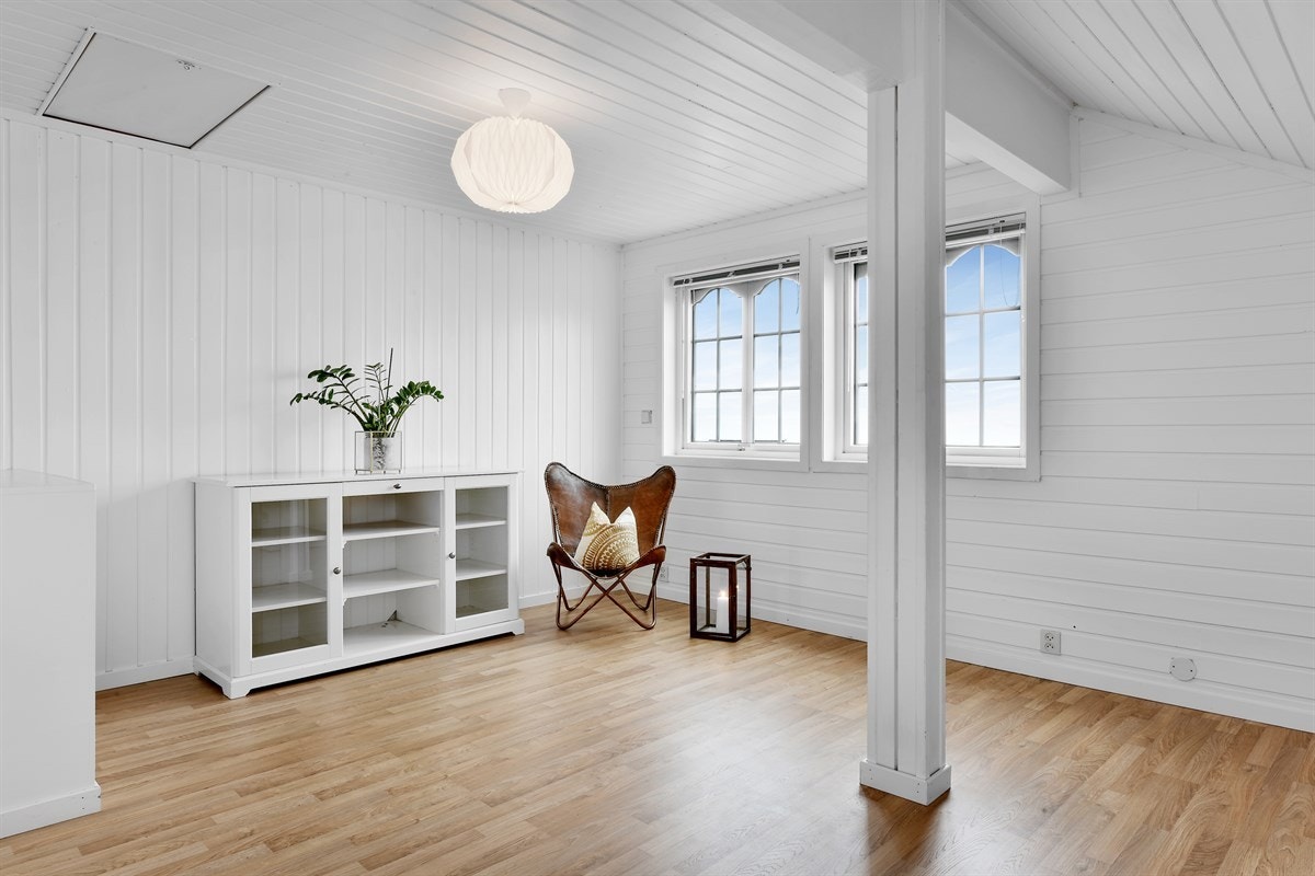 Loftstuen har laminatgulv, lysmalte vegger og lysmalt tak. Galleribilde