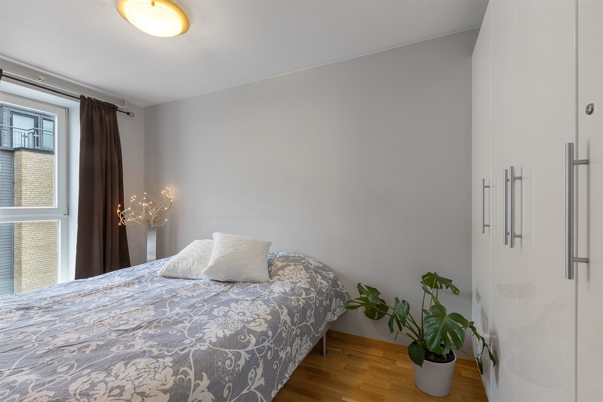 Lyst og pent soverom med god plass til dobbeltseng og nattbord Galleribilde