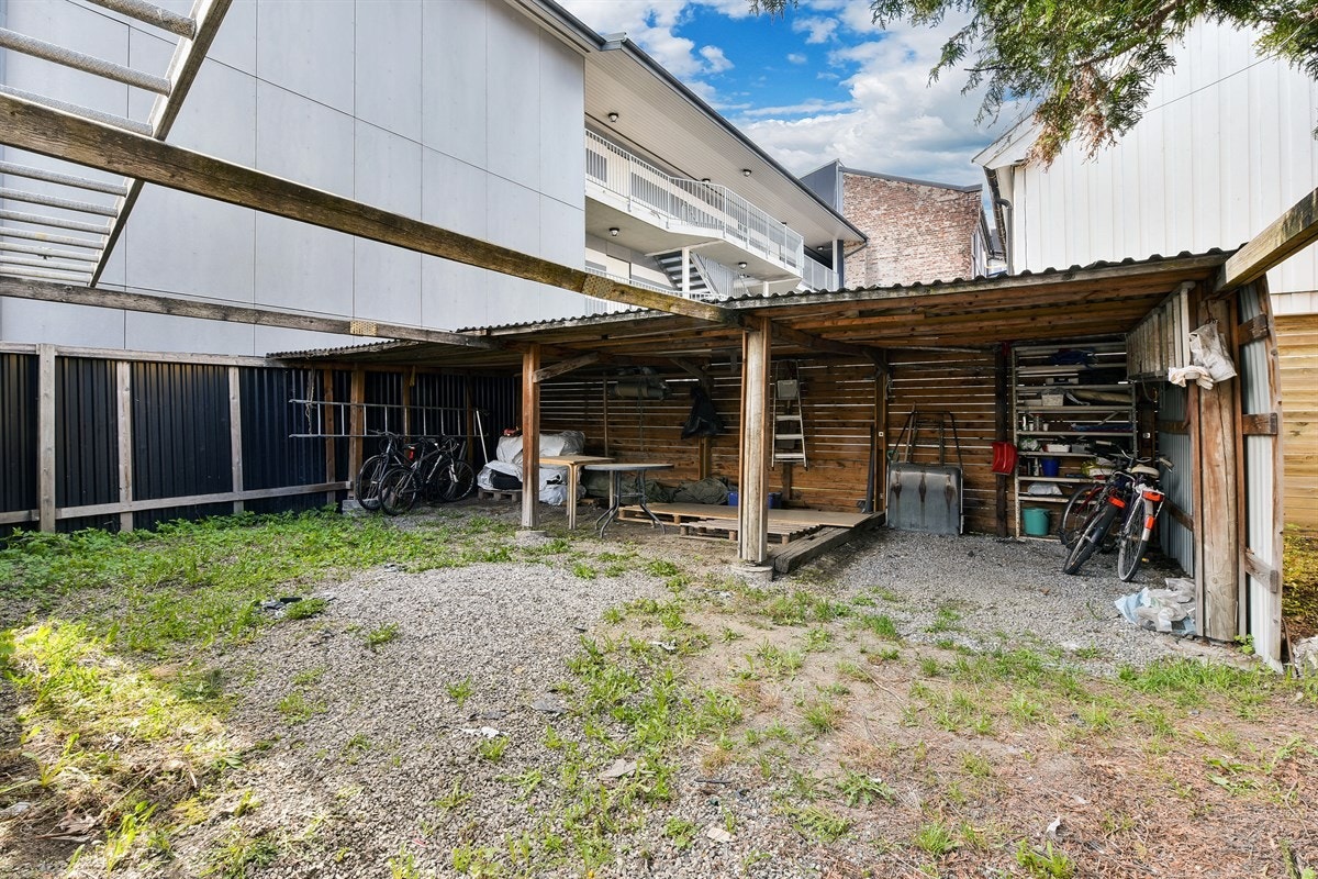 Tomten har en inngjerdet bakgård med carport der det er god plass til flere biler. Galleribilde