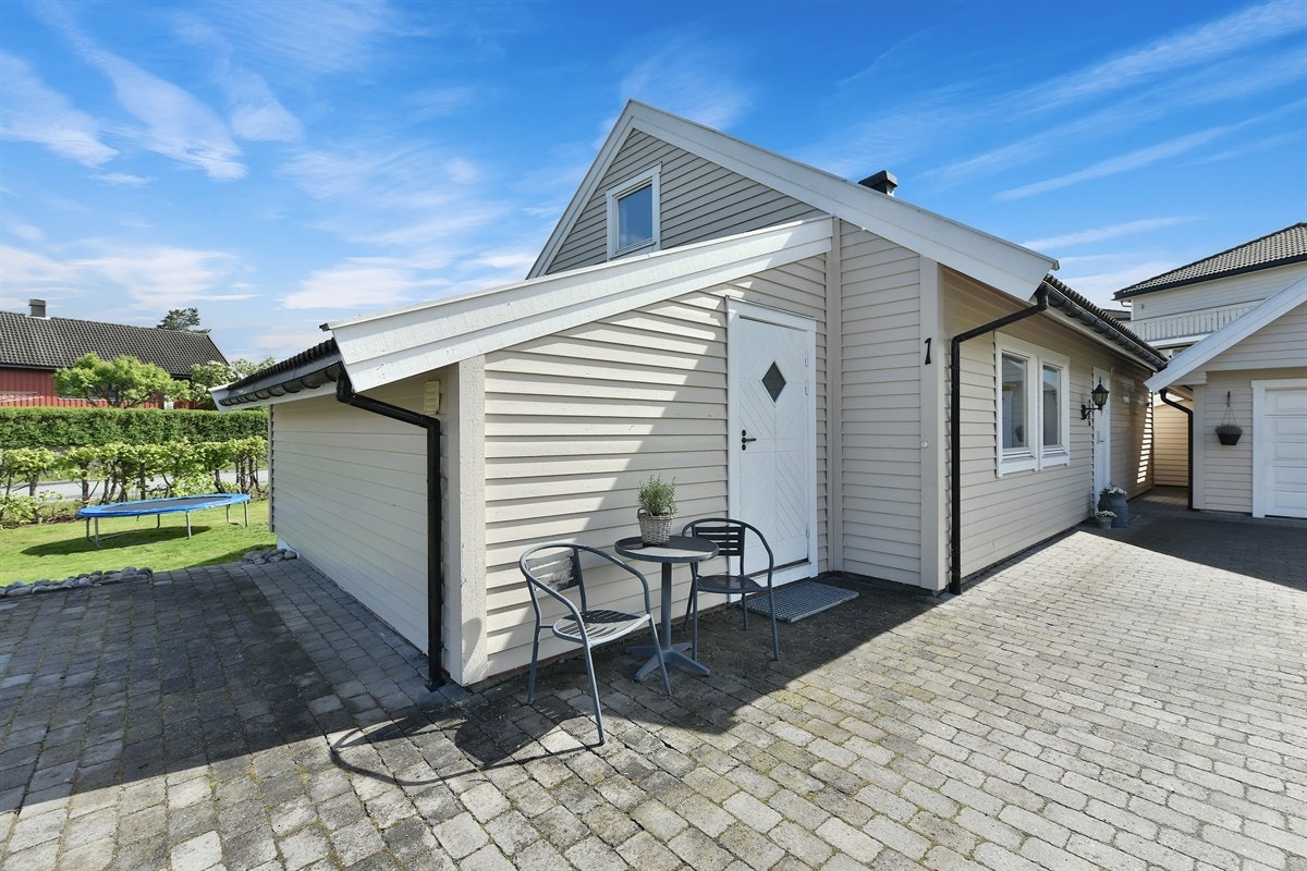 Gårdsplassen er steinsatt. Det åpne plenarealet legger til rette for ballspill, trampoline, lek og moro. Galleribilde