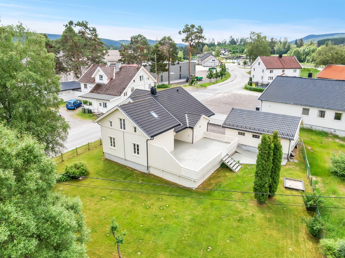 Pent opparbeidet uteområde med gressplen og stor terrasse Galleribilde