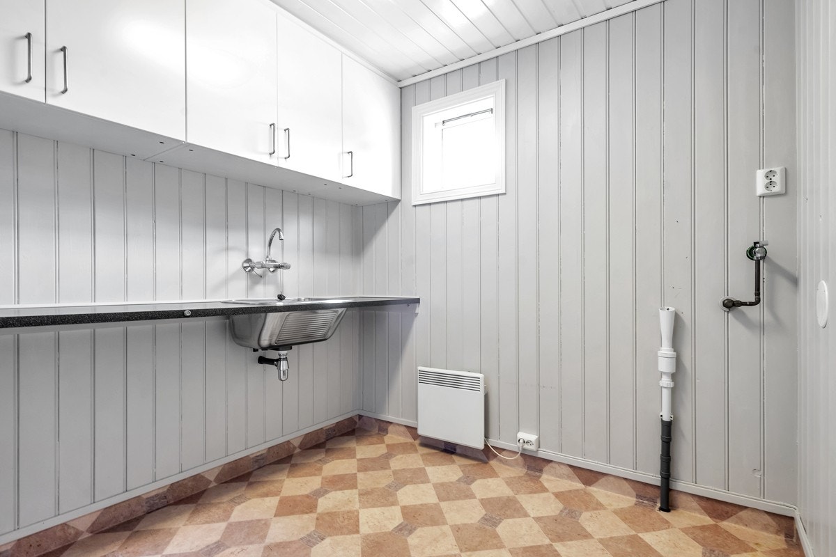 Praktisk vaskerom med opplegg for vaskemaskin og skapplass Galleribilde