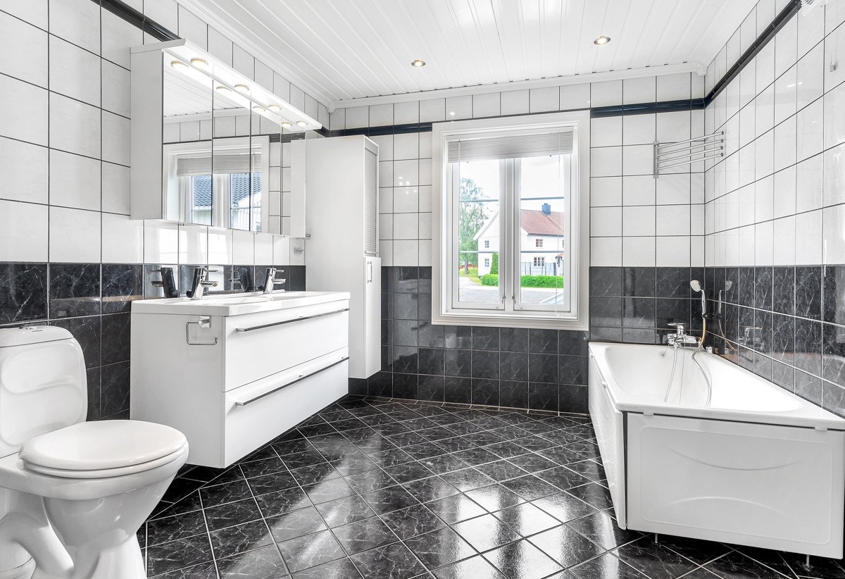 Bad i 1.etasje med servantinnredning, toalett, badekar og dusj Galleribilde