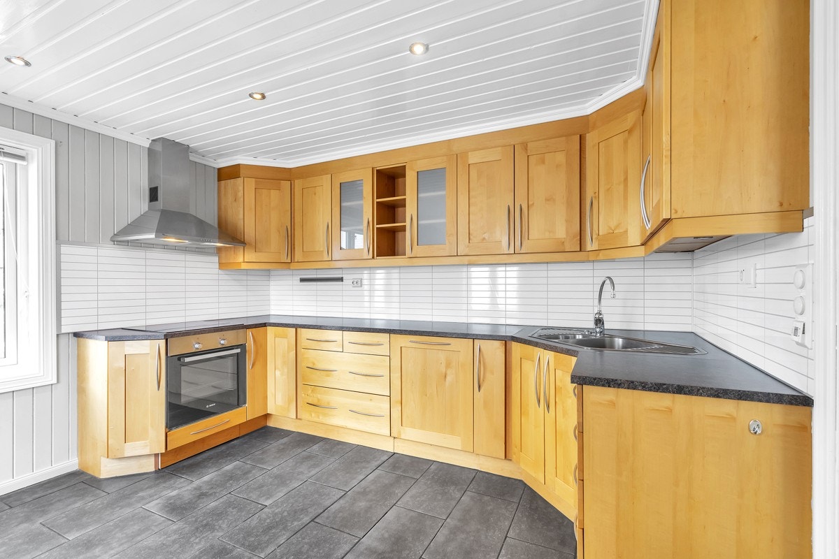 Romslig kjøkken med mye skap- og benkeplass Galleribilde