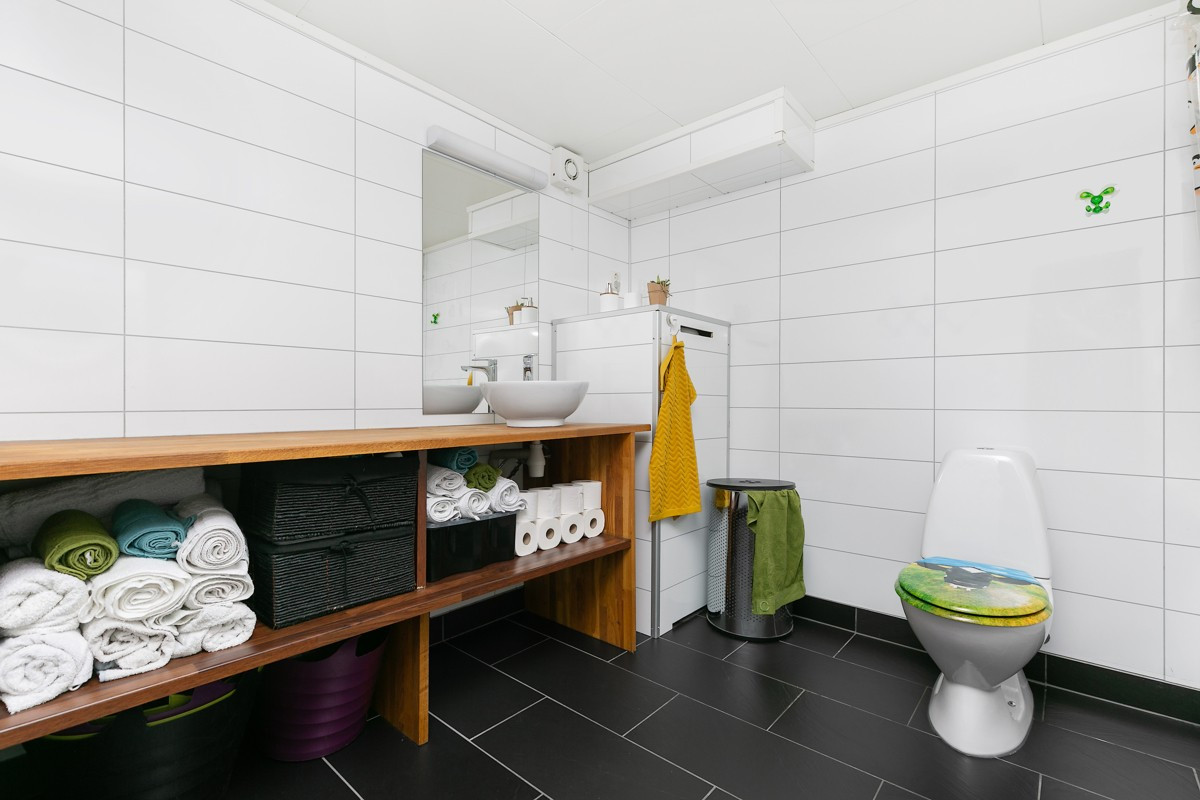 Bad/vaskerom er innredet med wc, badekar, heldekkende servant med speil og rikelig med skapplass, opplegg for vaskemaskin/tørketrommel, samt keramisk flis med gulvvarme