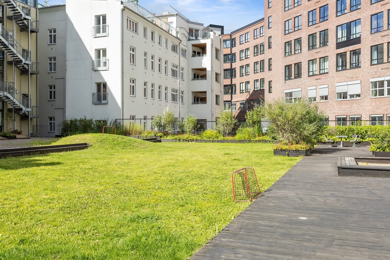 Meget pent opparbeidet bakgård med sittegrupper, plan og beplantning Galleribilde