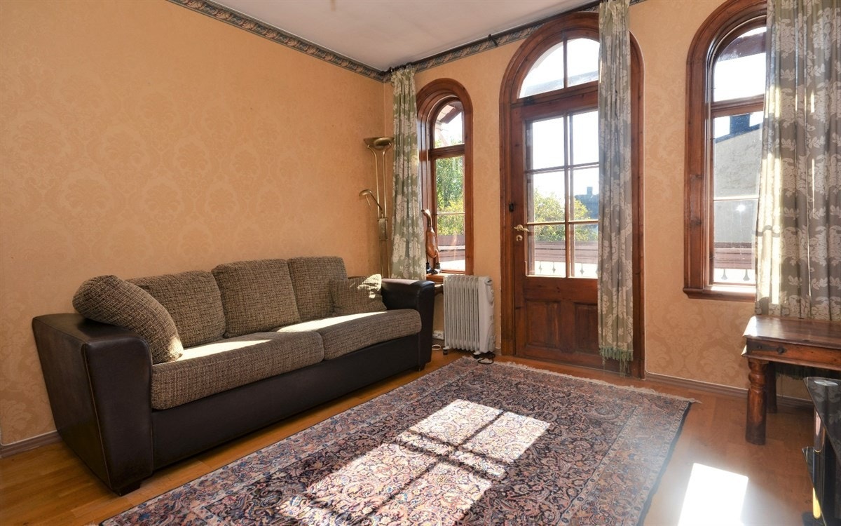 Stuen i arken i andre etasje med nydelige buede vinduer og utgang til altan. Galleribilde