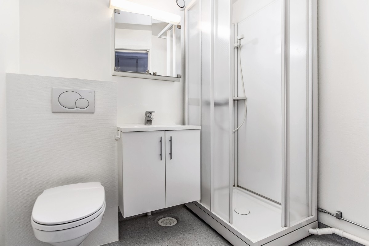 Bad fra byggeår som er oppgradert i senere tid i forbindelse med våtromsrehabilitering i Brl. Heldekkende servant på underskap med folierte fronter. Dusjkabinett med 2 skyvedører. Speilskap og lysarmatur på vegg. Opplegg for vaskemaskin. Galleribilde