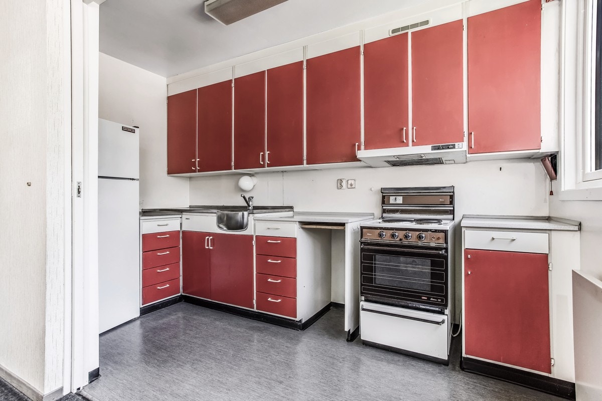 Eldre kjøkkeninnredning med malte heltre fronter. Heldekkende kjøkkenbeslag. Laminat benkeplate og ventilator med avtrekk ut. Galleribilde