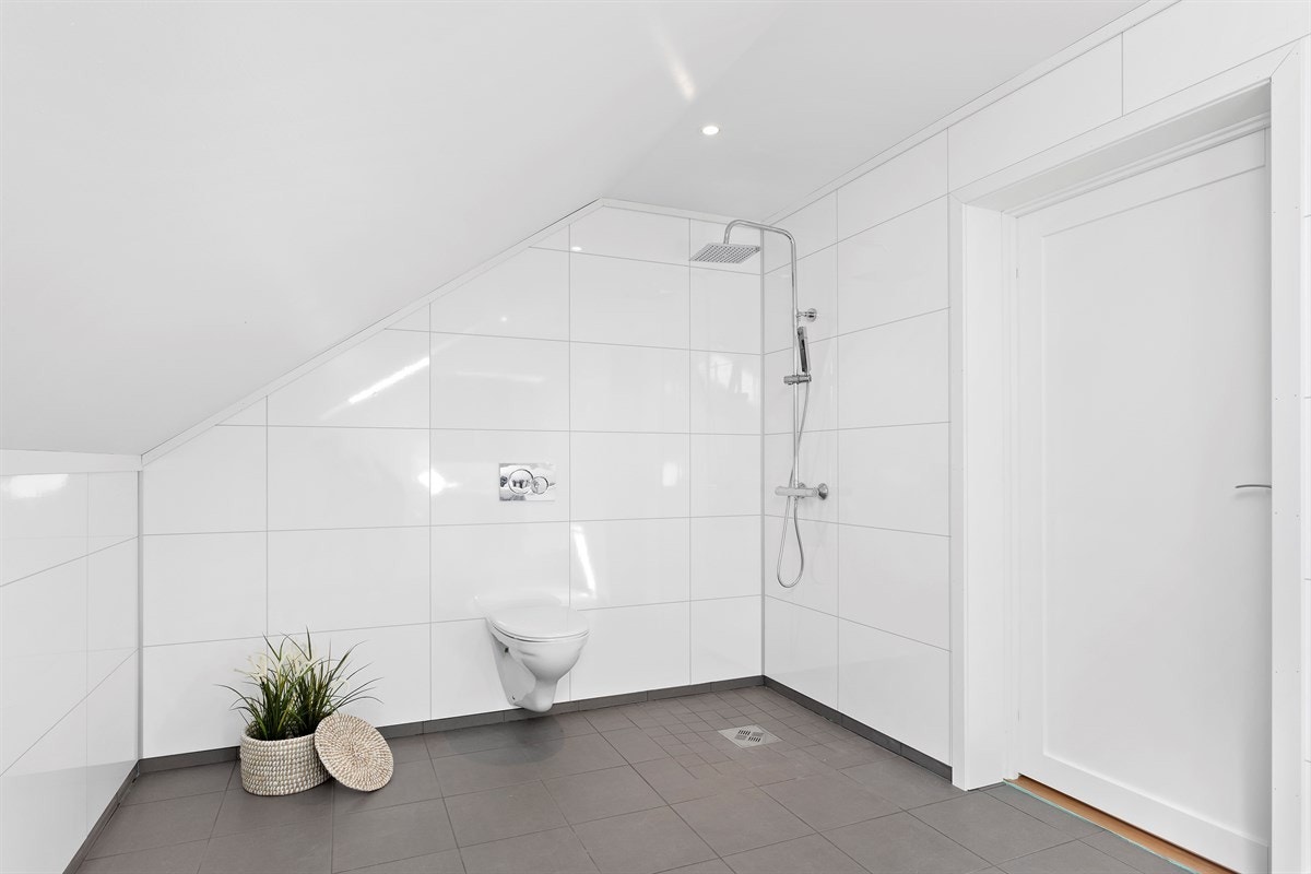 Overflatene består av keramiske fliser på gulv med varmekabler og baderomspanel på vegger. Galleribilde