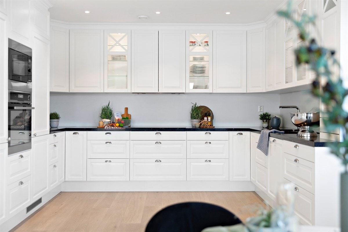Kjøkkenet er innredet med hvite profilerte fronter, silestone benkeplate av granittstein med kompositt vask og integrerte hvitevarer. Galleribilde