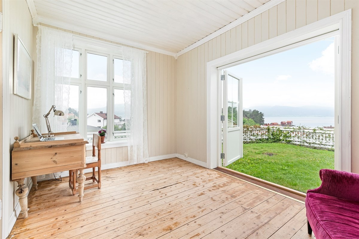 Mindre stue med tofløyet glassdør ut til hagen. Galleribilde